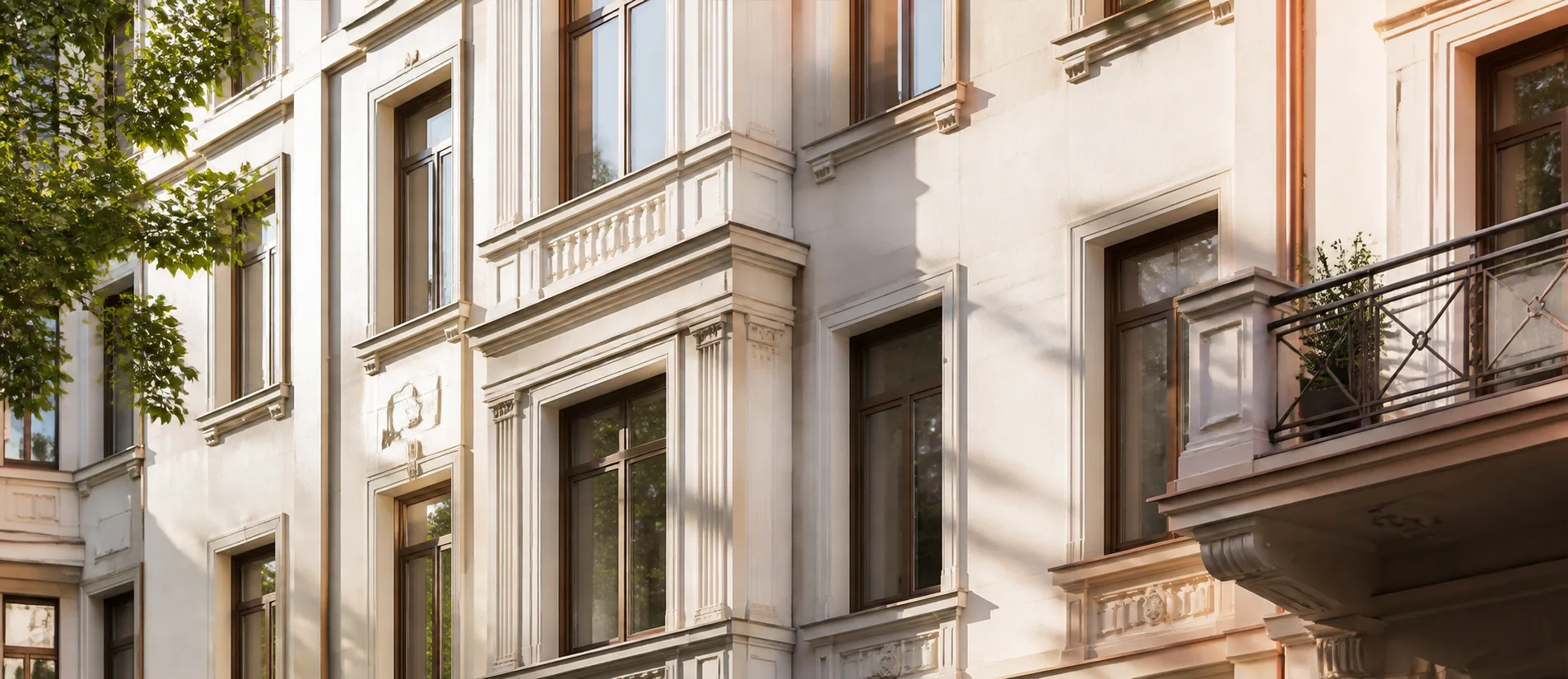 Helle Wohnfassade mit klarer Fensterordnung und warmen Metalldetails
